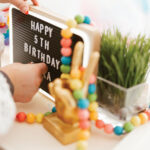 placing letters on a letterboard sign that reads Happy 5th Birthday