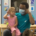 Kid-and-teacher-playing-telephone-at-the-CMCA-Clubhouse-HS