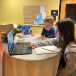 Alaina Stoll and Leo Horn work together on a laptop.