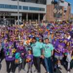 A-Sea-of-faces-wearing-purple-in-front-of-the-MU-arena-preparing-to-walk-to-support-Alzheimers