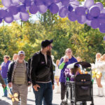 Purple-balloon-arch-hovers-over-people-walking-through-in-support-of-Ending-Alzheimers