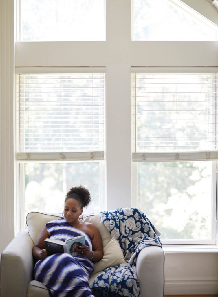 Adonica Coleman reading on her loveseat at home