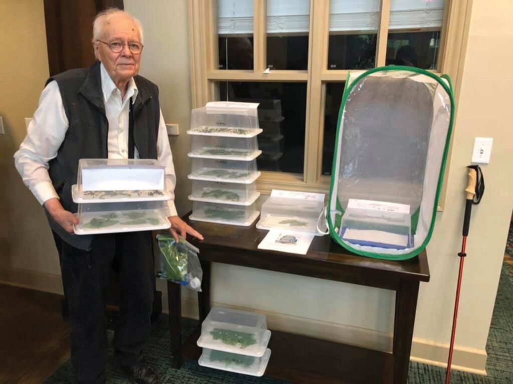 Dr. Hart holding containers of caterpillar eggs.