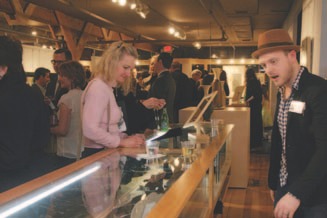 Gallery Curator Joel Sager helps a patron select jewelry to examine.