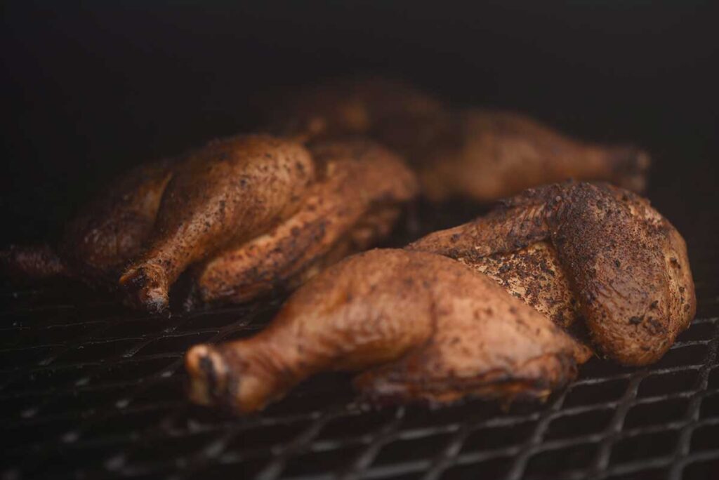 Image of chicken thighs bathed in smokey goodness on the grill at Irene's Mexican barbecue in Columbia Missouri.
