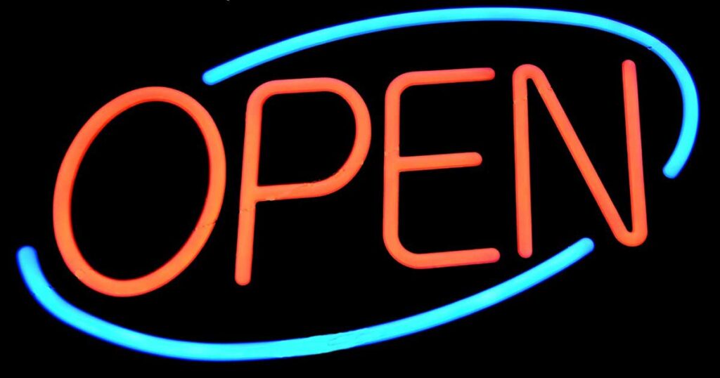 A colorful neon sign says OPEN.
