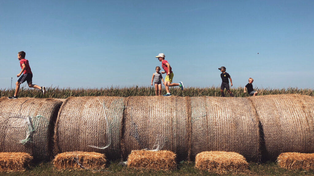 Kids running across hay bales at Shryock Callaway Farms