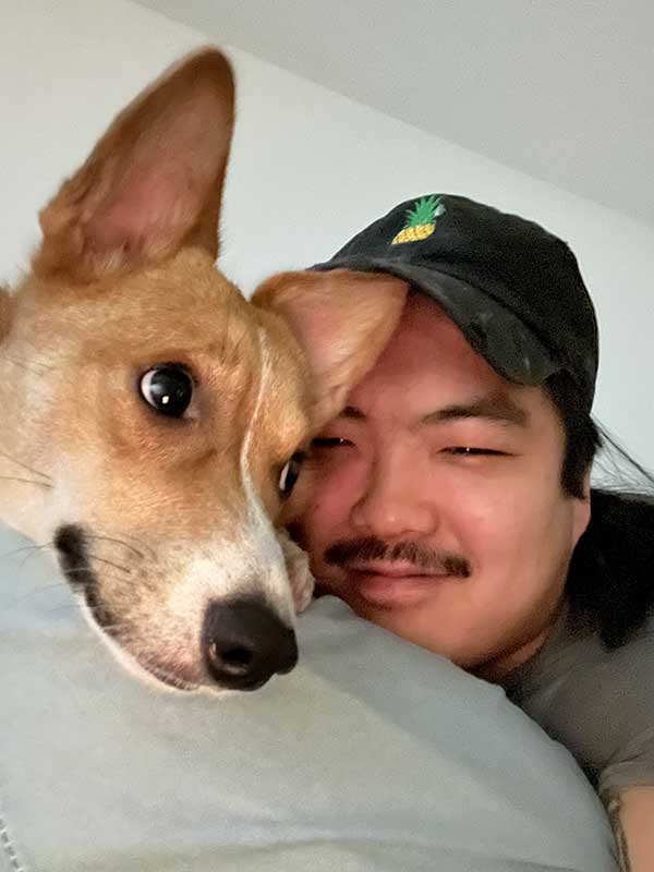 Vinnie DeBano smiles and poses with his corgi Kiki