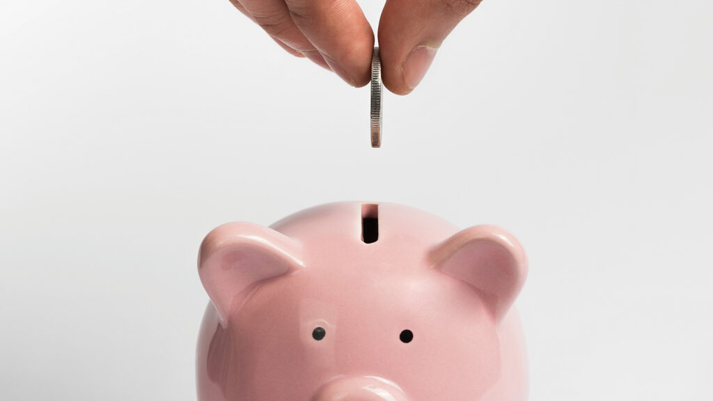 Depositing coins in a piggy bank for retirement