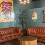 Corner Lounge With Leather Couches And Vintage Harpos Sign