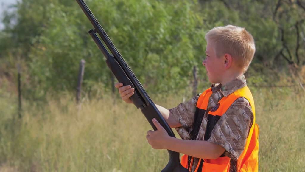 A young hunter patiently waiting using appropriate safety precautions