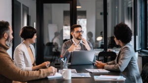 A Young Business Man Talking To A Group Of Professionals