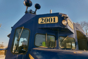 Railroad operator James Day sitting In front of locomotive 1200x800