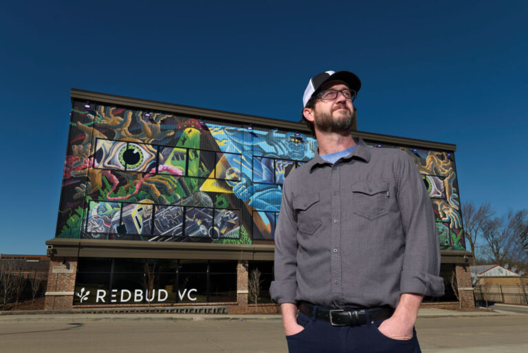 David Spear Posing In Front Of Redbud Vc Building Mural In The Arcade District