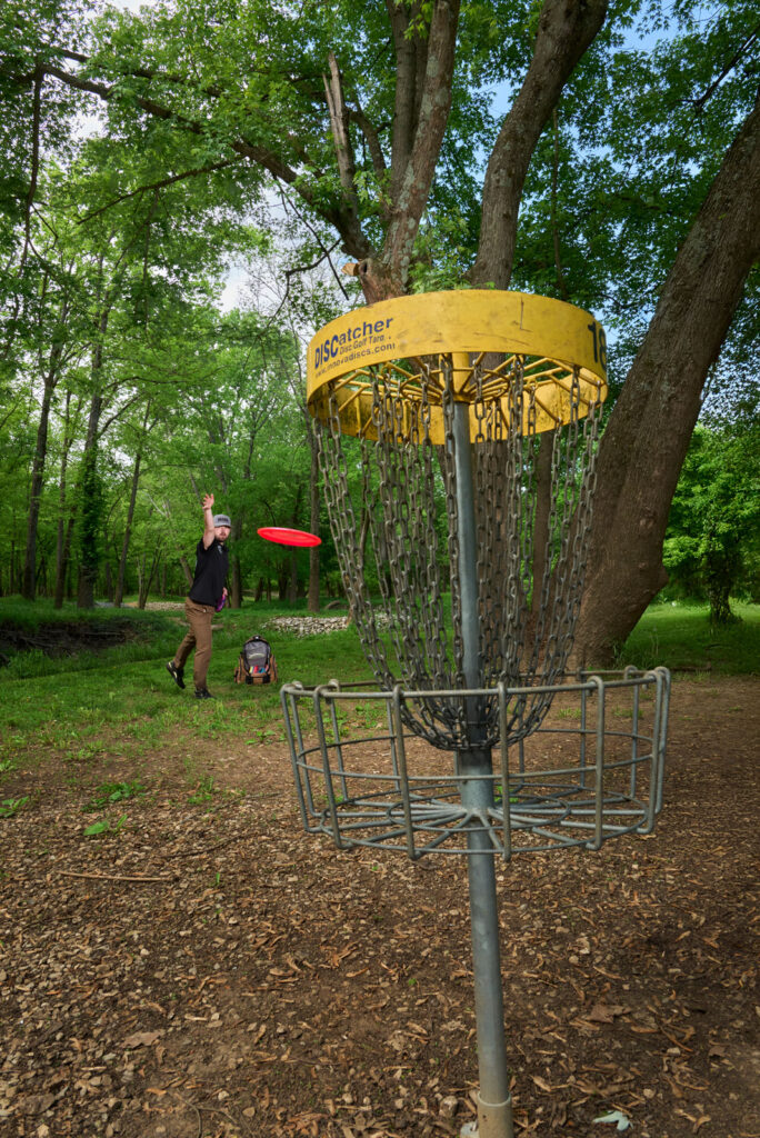 Pro Am Disc Golfer Chris Baker Throws Red Disc At Yellow Net