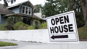 Open house sign pointing left, to a house at the end of a driveway