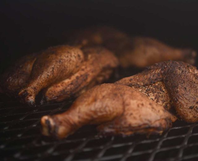 Image of chicken thighs bathed in smokey goodness on the grill at Irene's Mexican barbecue in Columbia Missouri.