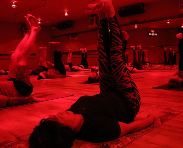 Sauna-Yoga-under-heat-lamps-participants-feet-in-the-air
