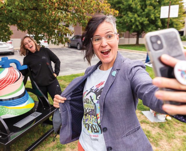 Shelly-Farnen-takes-a-selfie-with-the-bell-and-Meg-Wagler-behind-her