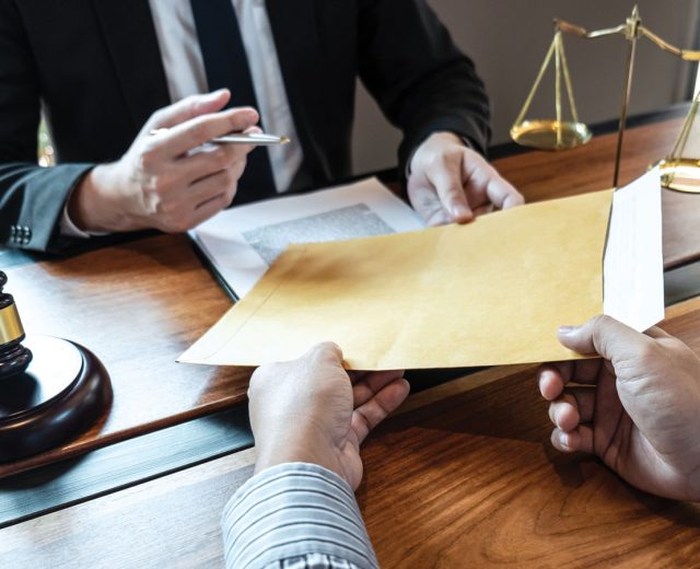 Featured Lawyer And Client Exchanging Title Insurance Papers