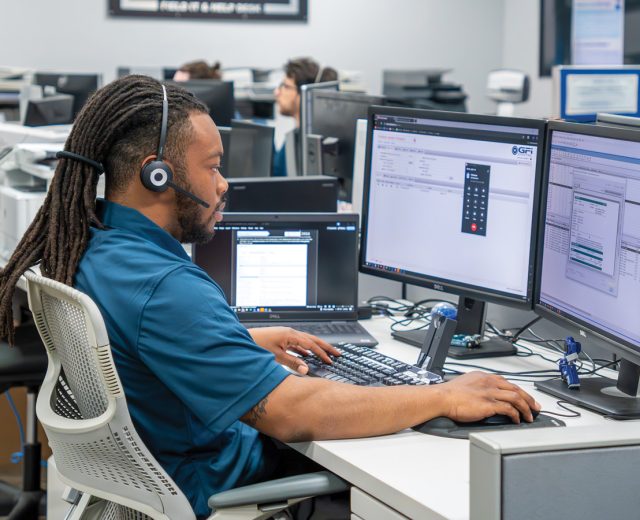 GFI Employee Sitting At A Help Desk