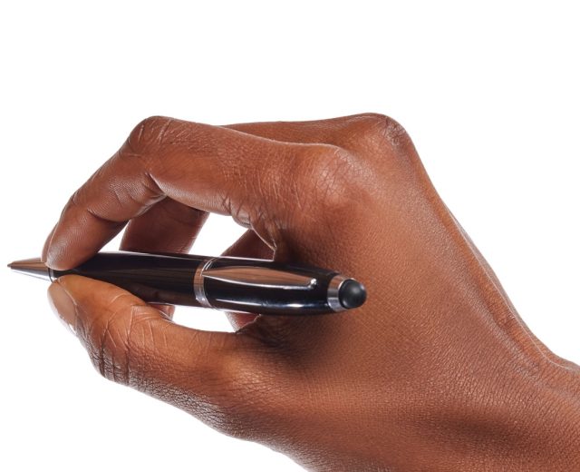 A hand holding a pen poised to sign on a white background.