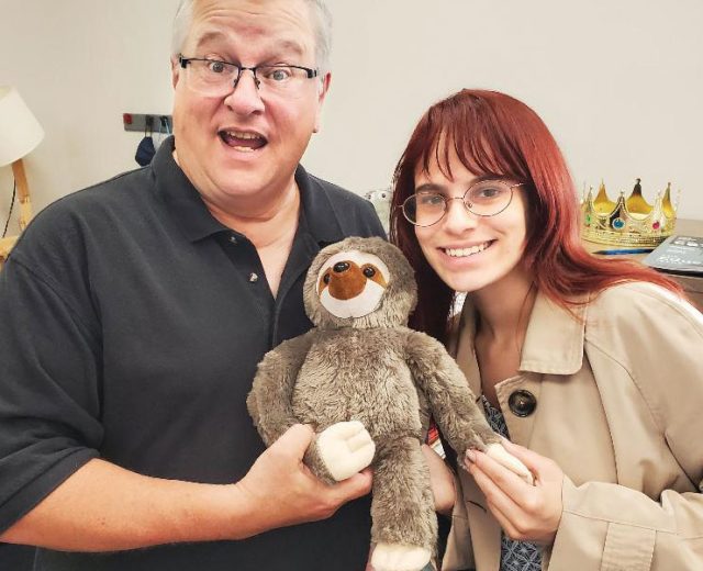 COMO Business Times editors Jodie Jackson Jr and Kelsey Winkeljohn, posing with a stuffed sloth