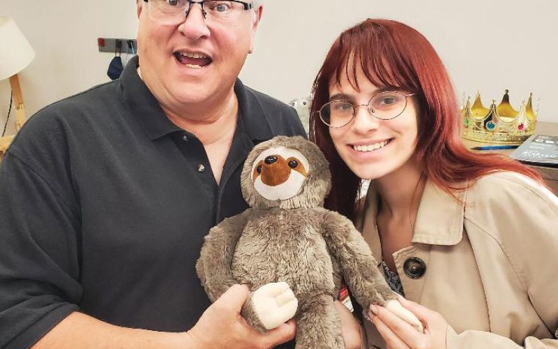 COMO Business Times editors Jodie Jackson Jr and Kelsey Winkeljohn, posing with a stuffed sloth