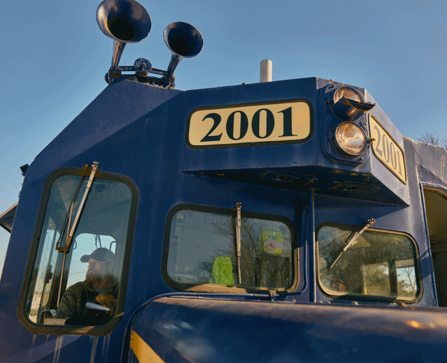 Railroad operator James Day sitting In front of locomotive 1200x800